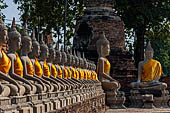 Ayutthaya, Thailand. Wat Yai Chai Mongkhon, saffron-draped Buddha statues inside the temple compound. 